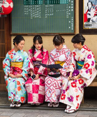 Kyoto, Japonya - 7 Kasım 2017: Bir grup kızı bir bankta bir kimono Sit. Yakın çekim.    