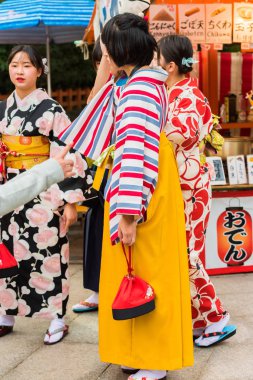 Kyoto, Japonya - 7 Kasım 2017: Bir şehir sokak üzerinde parlak bir kimono kız grubudur. Yakın çekim. Dikey.