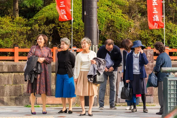 КЁТО, Япония - 7 ноября 2017 года: Группа пожилых туристов на экскурсию по улицам города. Копирование текста . — стоковое фото