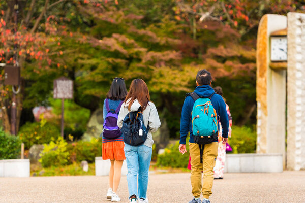Group of people in a city park in Kyoto, Japan. Copy space for text. Back view.