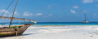 Zanzibar, Tanzanya - 8 Şubat. 2020: Sahilde ahşap tekne ve çarpıcı turkuaz su.