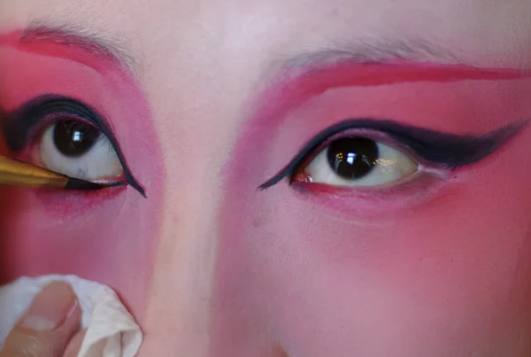 A chinese opera actress is painting her face backstage — Stock fotografie