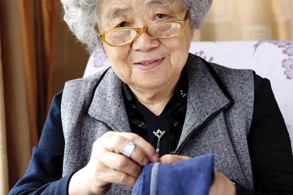 Una sonrisa cosiendo abuela — Foto de Stock