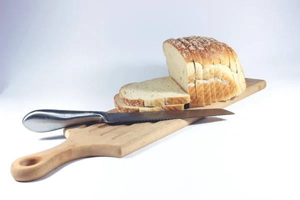 Pão fatiado e tábua de corte no fundo branco isolado — Fotografia de Stock