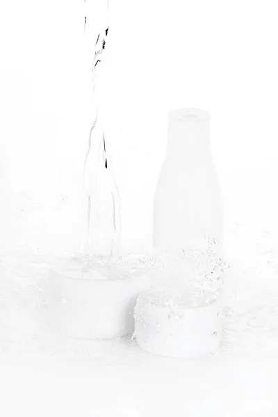 Капли воды, падающие на бутылки и коробки — стоковое фото