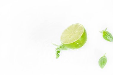half of lime with green leaves clipart