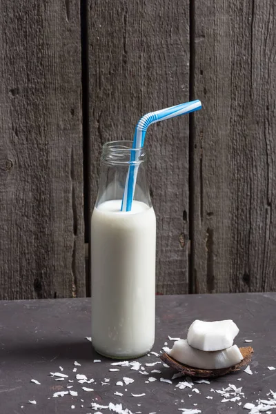 Pedaços de coco com flocos e leite em garrafa — Fotos gratuitas