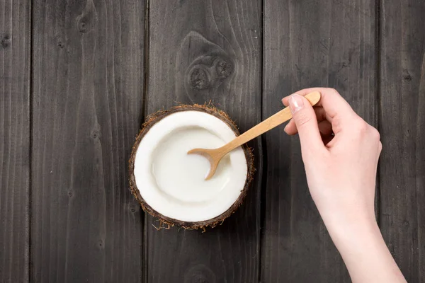 Mélange de lait à la main dans la noix de coco avec cuillère — Photo