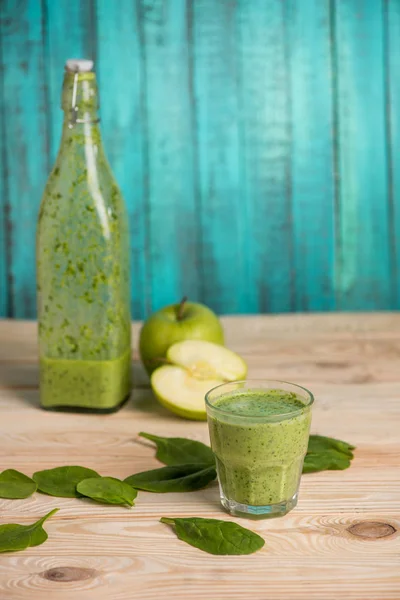 Manzanas con batido en vidrio sobre mesa de madera — Foto de Stock