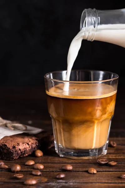 Pouring milk into coffee process — Stock Photo, Image