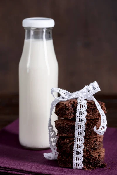 Bottle of milk with brownie cakes on napkin — Free Stock Photo