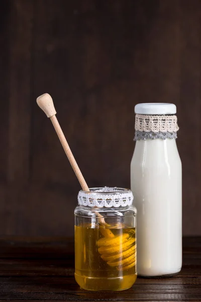 Glass bottle of milk with honey in jar — Stock Photo, Image