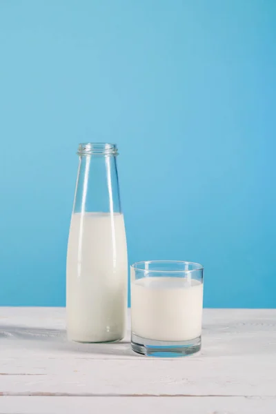 Milk in glass and bottle on tabletop — Stock Photo, Image