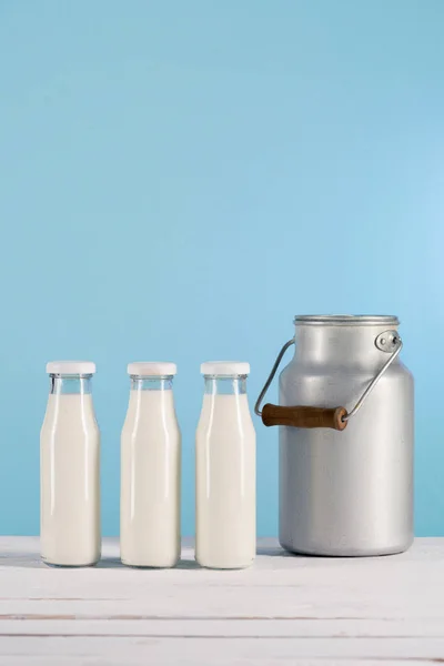 Glass bottles of milk with can — Stock Photo, Image