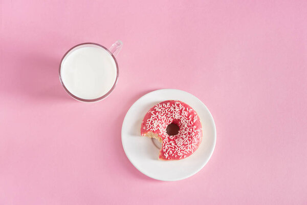 glass cup of milk with donut on plate