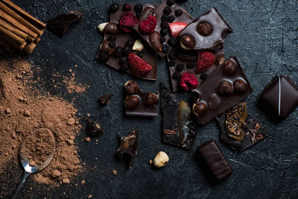 Pieces of chocolate with nuts and berries with cinnamon — Stock Photo, Image