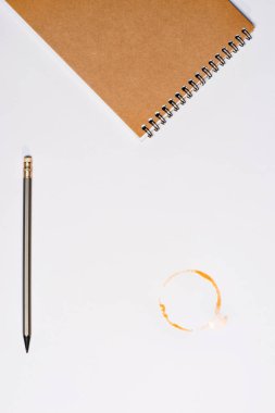 defter ile kalem ve kahve lekesi