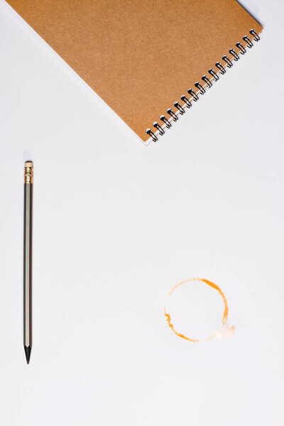 ноутбук с карандашом и пятном от кофе
