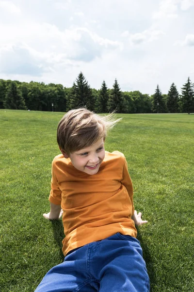 Boy resting on green lawn — Free Stock Photo