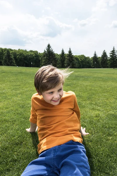 Niño descansando en el césped verde — Foto de stock gratis