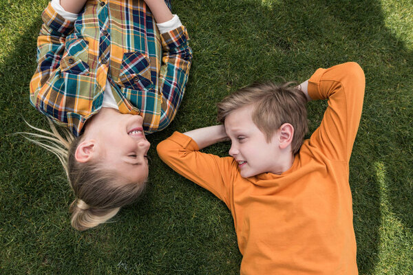 kids lying on green lawn