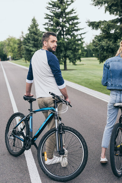 Человек, стоящий рядом с велосипедом
