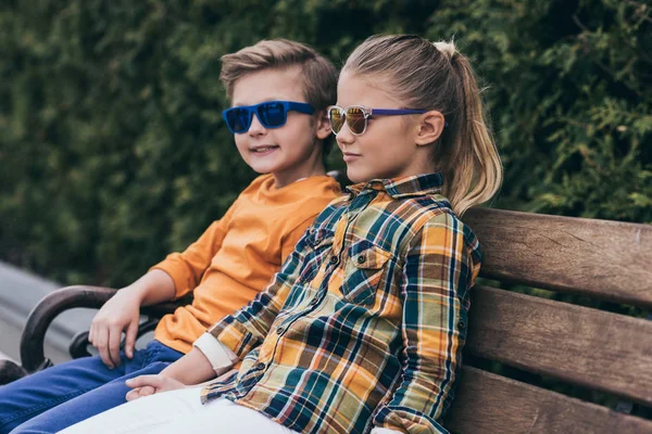 Little kids sitting on bench at park — Stock Photo, Image