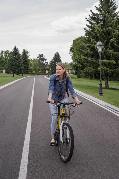 Mulher andar de bicicleta na estrada de asfalto — Fotografia de Stock