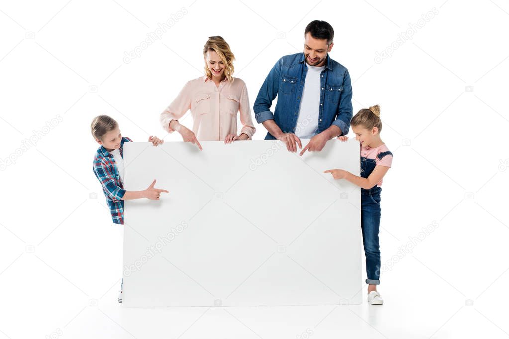 Smiling parents and kids pointing at blank banner isolated on white