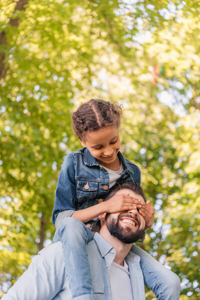 Father carrying daughter on shoulders 