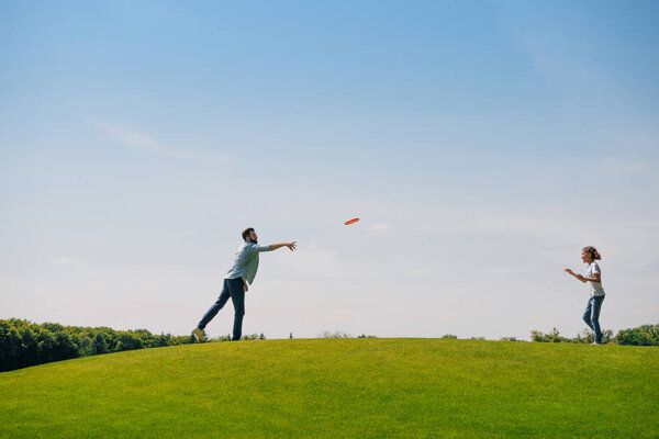 Father and daughter playing with flying disk 