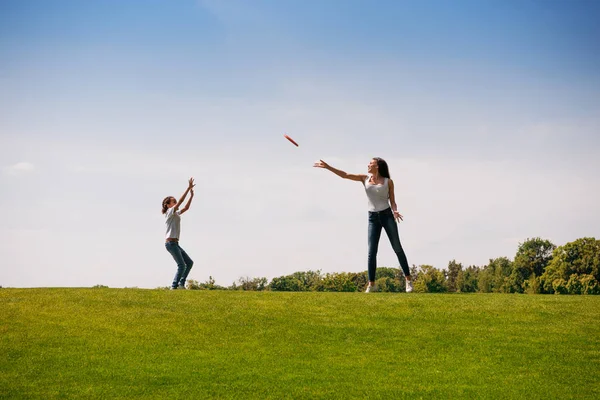 Мать и дочь играют с летающим диском — стоковое фото
