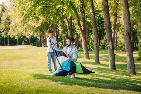 Father helping daughter with kite — Free Stock Photo