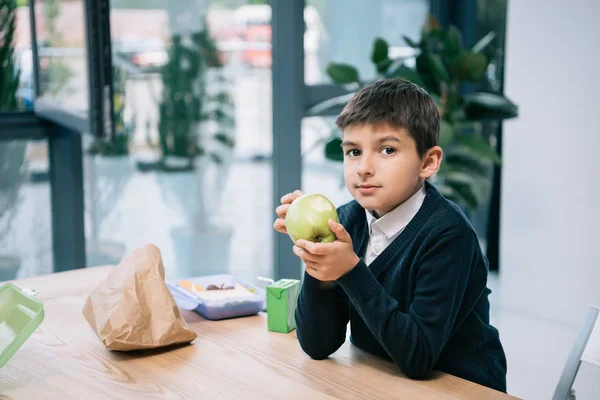 Школьник ест яблоко — стоковое фото