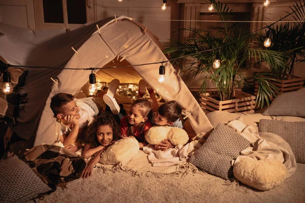 Multiethnic children resting in tent — Stock Photo, Image