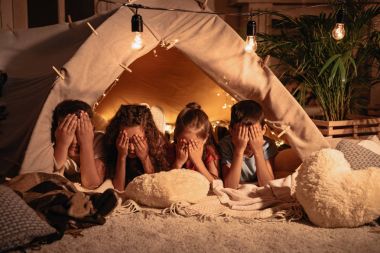 children resting in tent at home clipart