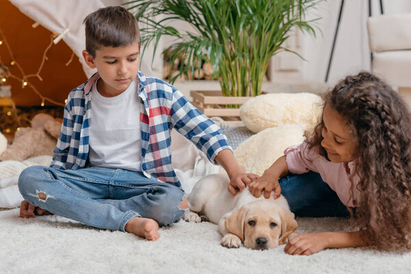 multicultural children with labrador puppy