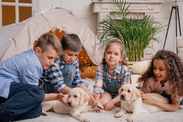 multiethnic children with labrador puppies