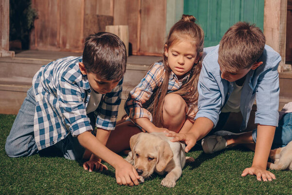 kids with cute labrador puppy