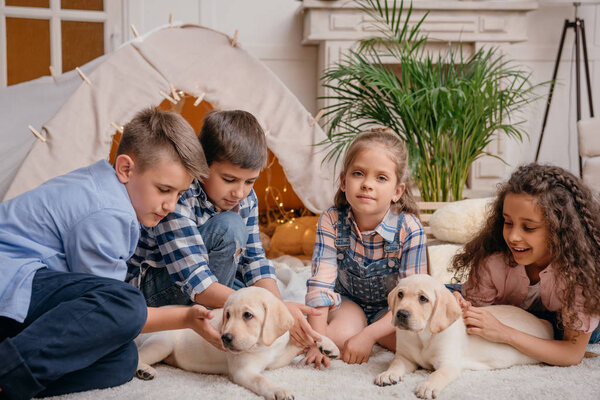 Niños multiétnicos con cachorros labrador — Imagen de stock Niños multiétnicos con cachorros labrador Imagen De Stock