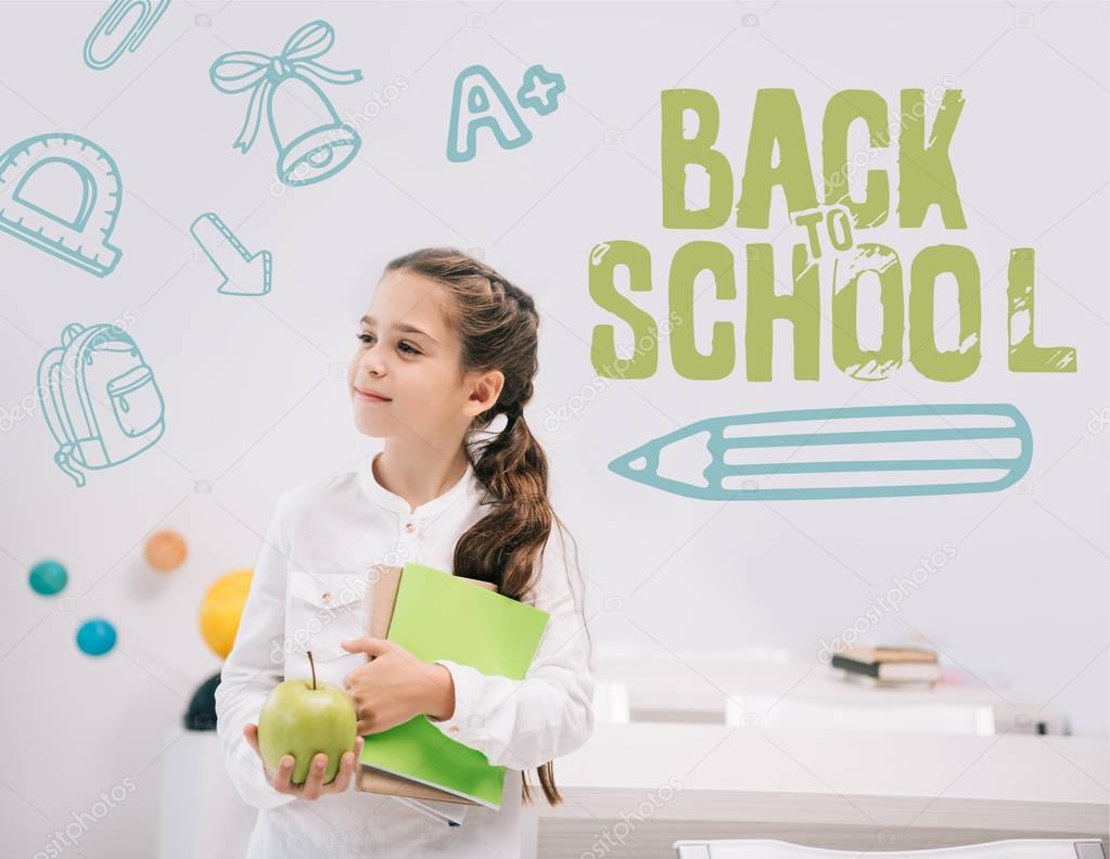 Schoolgirl with apple and textbooks