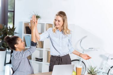 multiethnic businesswomen giving high five clipart