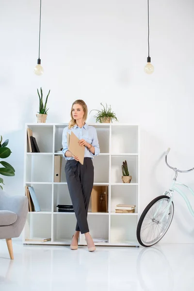 Geschäftsfrau mit Arbeitstagebuch im Büro — kostenloses Stockfoto