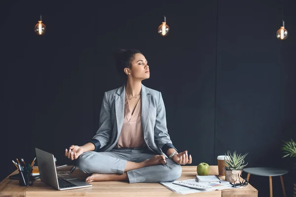 Afro-americana empresária meditando no escritório — Fotografia de Stock