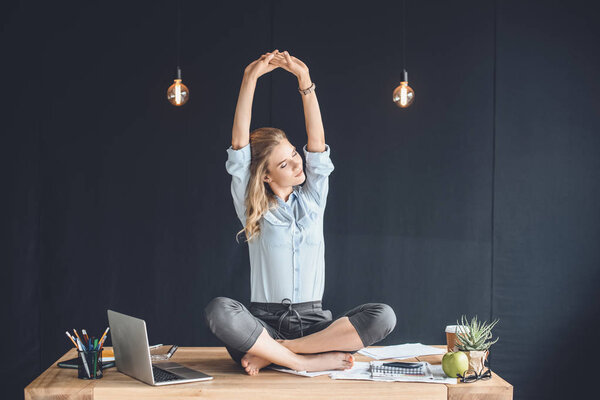 business woman sitting on table in office
