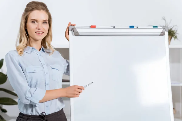 businesswoman pointing at white board