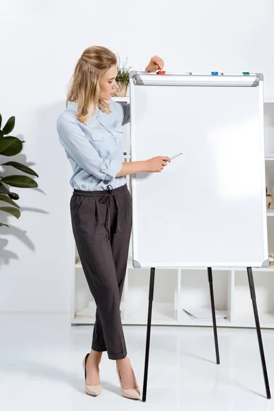Business woman pointing at white board — стоковое фото
