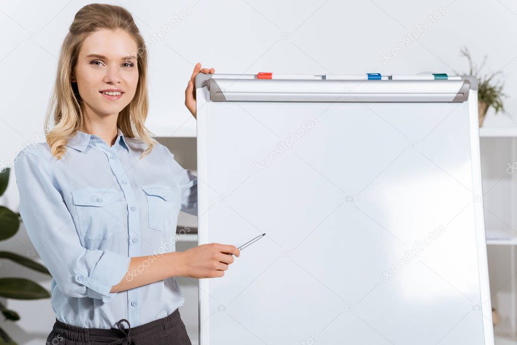 businesswoman pointing at white board