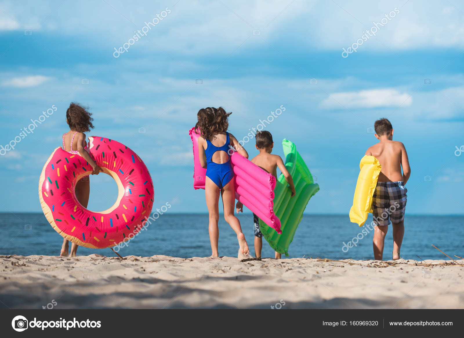 Kids with inflatable mattresses on beach — Stock Photo © alebloshka