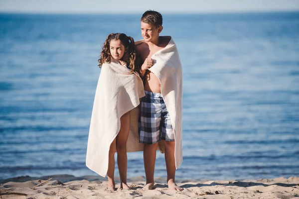 Niño y niña en la orilla del mar — Foto de stock gratis